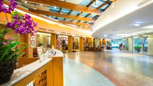 a lobby of a building with purple flowers on a counter at Luminous Hot Spring Resort & SPA in Luye +95 photos