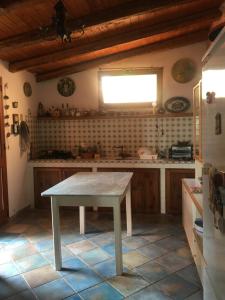 uma cozinha com uma mesa no meio em villa vista mare spiaggia privata em Scopello