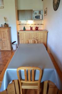 シャテルにあるHameau 4 saisons 124C - Appartement 5 pers - Chatel Reservationのキッチン(テーブル、椅子2脚、テーブル付)、