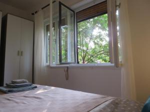 a bedroom with a bed and a window at Apartman Otvoreno polje in Arandelovac