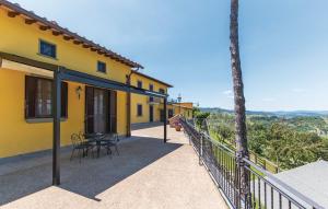 una casa gialla con balcone arredato con tavolo e sedie di Villa Ghiandai ad Arezzo