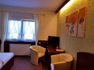 ein Hotelzimmer mit einem Bett, einem Schreibtisch und Stühlen in der Unterkunft Hotel Restaurant Jägerhof in Düren - Eifel