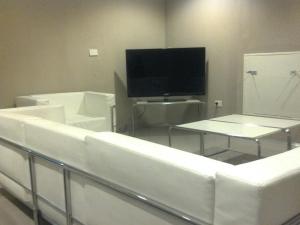 a living room with white furniture and a flat screen tv at Costanera Hotel in Puerto Madryn