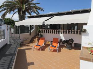 a patio with two chairs and an umbrella at Casa La Barca in Playa Honda