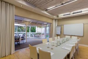 uma sala de conferências com uma mesa longa e cadeiras em Quarry Lake Inn em East London