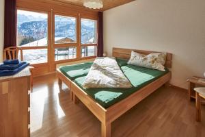 Schlafzimmer mit einem Bett und einem großen Fenster in der Unterkunft Ferienwohnung Leuweli in Hasliberg