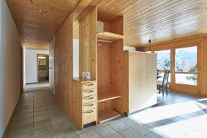 a room with wooden walls and a desk and a table at Ferienwohnung Leuweli in Hasliberg