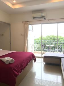 ホアヒンにあるBaan Pak I-Un Hua Hinのベッドとバルコニーのある寝室