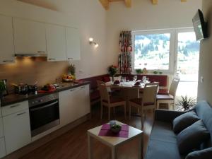a kitchen and living room with a table and a couch at Apart Diamant in Nauders