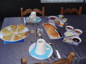 a table with a blue table cloth with food on it at les Voiries chambres d'hotes in Fleury