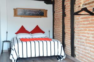 a bed in a room with a brick wall at Andra Mari Portua in Bermeo