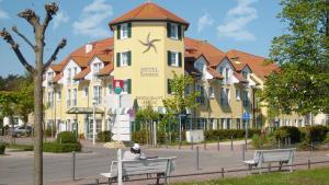 a person sitting on a bench in front of a building at Ferienhaus Seepferdchen in Baabe