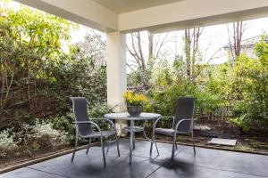 Your Home Away from Home في ملبورن: طاولة وكراسي على فناء مع حديقة