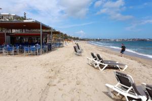 - une plage avec des chaises, des tables et l'océan dans l'établissement Apartamento vacacional, à Salou