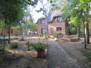 uma casa no meio de um quintal com árvores em Kruger Safari Animal Encounter em Marloth Park