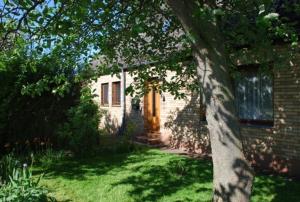 a brick house with a tree in the yard at Ferienhaus an der Orther Reede in Fehmarn +8 photos