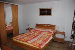 a bedroom with a bed with a striped comforter at Ferienhaus an der Orther Reede in Fehmarn
