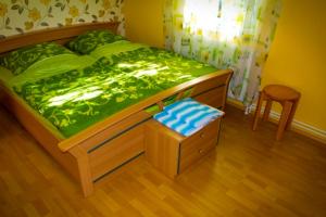 a bedroom with a bed with a green comforter and a chair at Ferienhaus Doris in Dwasieden