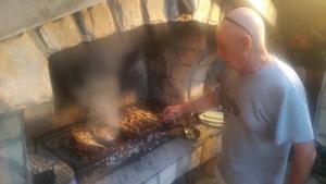 a man standing in front of a brick oven at Apartman i Sobe Čule Cres in Cres