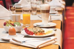 una mesa cubierta con platos de comida y bebida en Mövenpick Hotel Frankfurt City Messe, en Frankfurt