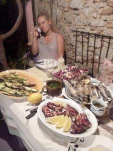 a woman taking a picture of a table of food at Apartman i Sobe Čule Cres in Cres