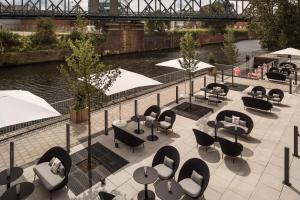 a row of tables with chairs and umbrellas at INNSiDE by Meliá Hamburg Hafen in Hamburg