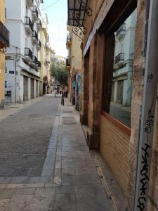an empty city street with a dog walking down the street at FLORIT FLATS - The Mercado Central Apartment in Valencia