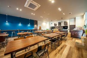 a restaurant with wooden tables and chairs and blue walls at Mizuho Inn Iwami Masuda in Masuda