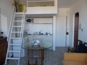 a kitchen with a glass table and a ladder at Casa Montagnese in Anacapri