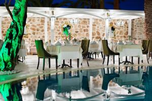 a restaurant with a table and chairs next to a pool at Elegance East Hotel in Antalya