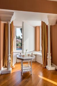 a living room with a table in front of a window at Villa della Pergola Relais et Chateaux in Alassio