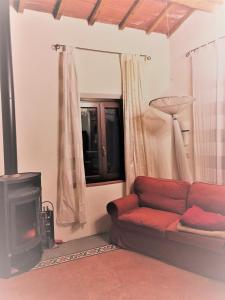 un soggiorno con divano rosso e camino di Budget Romance Tower Studio a Lari