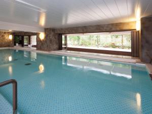 a large swimming pool in a hotel with a window at Hotel Pearl City Kobe in Kobe