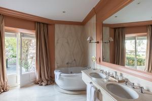 a bathroom with two sinks and a large mirror at Villa della Pergola Relais et Chateaux in Alassio +59 photos