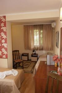 a hotel room with two beds and a table at Hotel Triumph in Nova Zagora