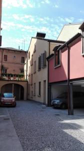 dos coches estacionados en un estacionamiento junto a los edificios en Art Hotel Al Fagiano, en Padua