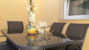 a glass table with wine glasses and flowers on it at Smeralda House in Viareggio