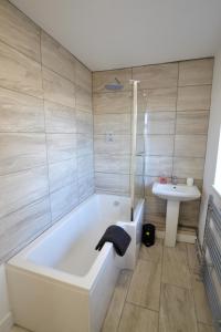 a bathroom with a bath tub and a sink at South Coast Haven Apartments in Peacehaven