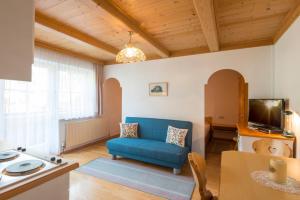 ein Wohnzimmer mit einem blauen Sofa und einem TV in der Unterkunft Golfappartements in Bad Gastein