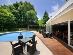 a patio with a table and chairs next to a swimming pool at Yutorelo Karuizawa Hotel in Karuizawa