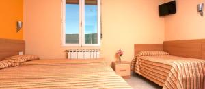sypialnia z dwoma łóżkami i oknem w obiekcie HOSTAL EUROPA pensión w mieście Irún