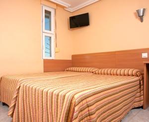 Łóżko lub łóżka w pokoju w obiekcie HOSTAL EUROPA pensión