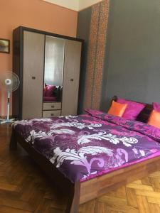 リヴィウにある1 Starodubska Apartmentのベッドルーム(紫色の掛け布団付きのベッド1台付)