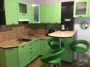 リヴィウにある1 Starodubska Apartmentの緑のキャビネットと緑の椅子が備わる緑のキッチン