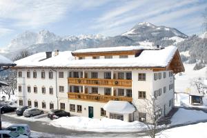 a building in the snow with mountains in the background at Der Schwendterwirt in Schwendt