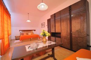 ein Wohnzimmer mit einem Tisch und ein Schlafzimmer in der Unterkunft Vila Helena in Liptovský Ján