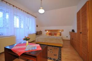 Schlafzimmer mit einem Bett, einem Schreibtisch und einem Tisch in der Unterkunft Vila Helena in Liptovský Ján
