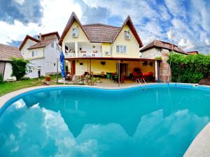 a house with a swimming pool in front of a house at Pensiunea Vila Silva I in Haţeg
