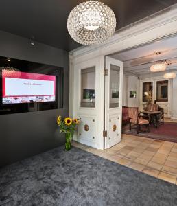 a lobby with a television and a vase of flowers at Hotel Blume - Swiss Historic Hotel in Baden