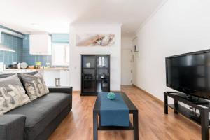 a living room with a couch and a flat screen tv at Sunny atic with terrace - Close to Camp Nou and Bcn Fair in Hospitalet de Llobregat